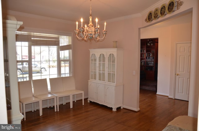 dining room with an inviting chandelier, crown molding, baseboards, and wood finished floors