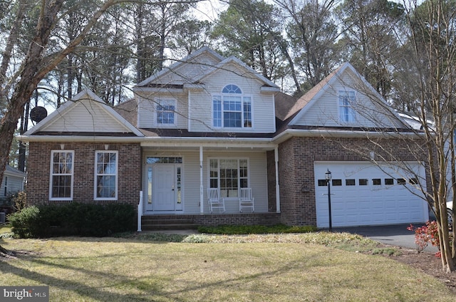 view of front of home with driveway, a porch, a front lawn, a garage, and brick siding