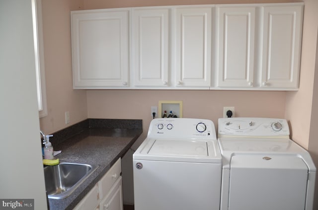 laundry area featuring washer and clothes dryer, cabinet space, and a sink