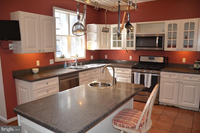 kitchen featuring a sink, dark countertops, open shelves, and stainless steel appliances