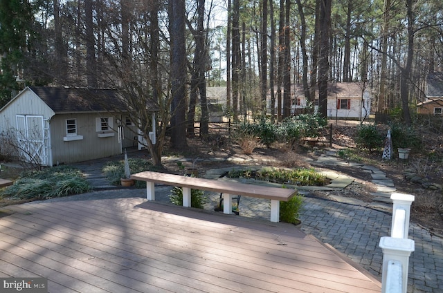 wooden deck featuring an outdoor structure and a shed