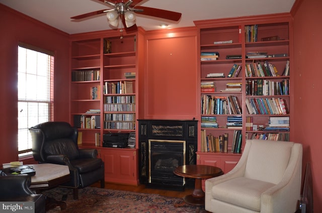 sitting room featuring wood finished floors, a fireplace, a wealth of natural light, and ceiling fan