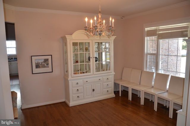 unfurnished room featuring a notable chandelier, ornamental molding, a sink, wood finished floors, and baseboards