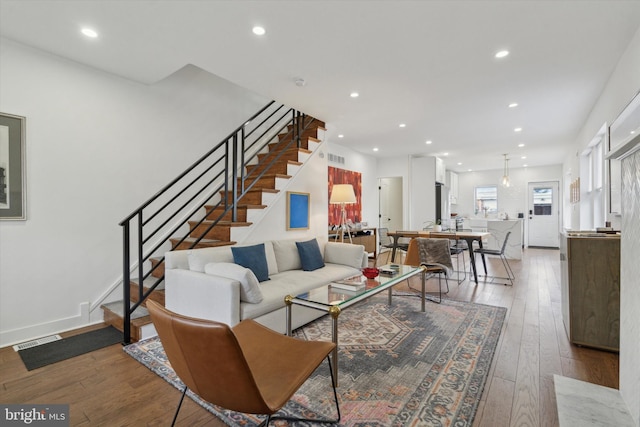 living area featuring hardwood / wood-style flooring, stairway, and recessed lighting