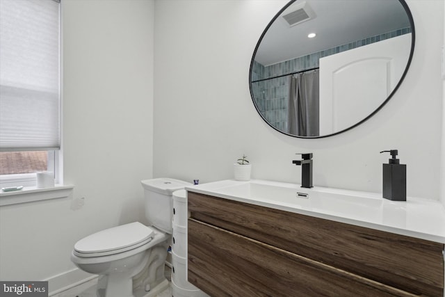 bathroom with visible vents, curtained shower, toilet, and vanity