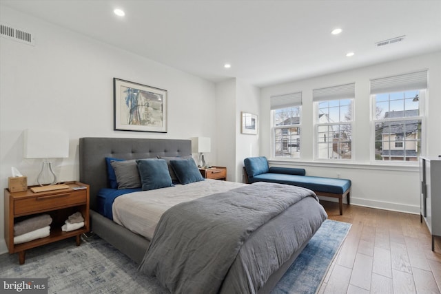 bedroom with recessed lighting, wood finished floors, and visible vents