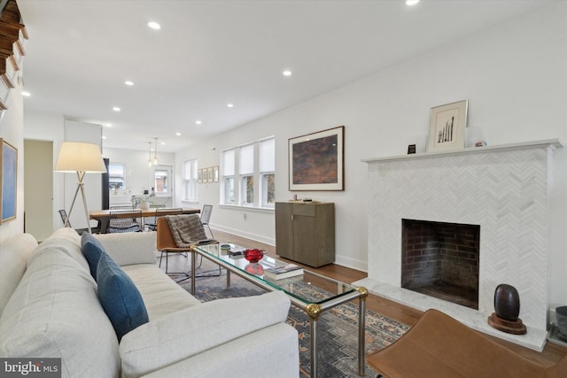 living room with recessed lighting, a fireplace, baseboards, and wood finished floors