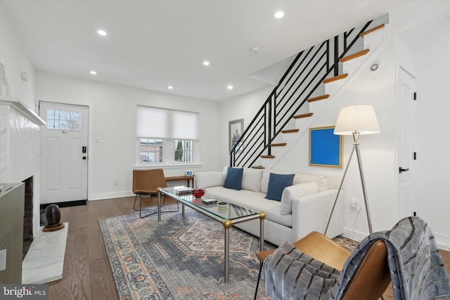 living area featuring recessed lighting, a wealth of natural light, wood finished floors, and stairs