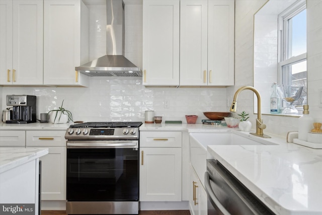 kitchen featuring decorative backsplash, white cabinets, wall chimney exhaust hood, and stainless steel appliances