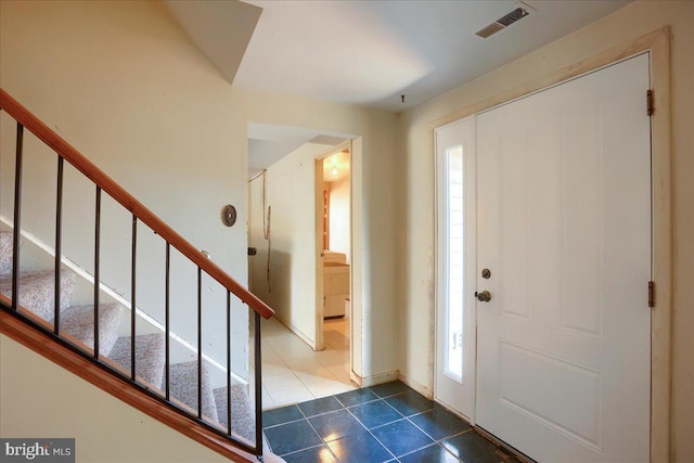 tiled foyer featuring visible vents and stairway