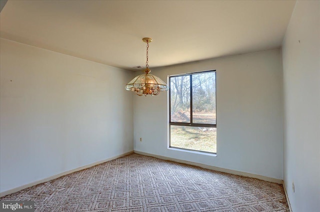 unfurnished room featuring an inviting chandelier, light colored carpet, and baseboards