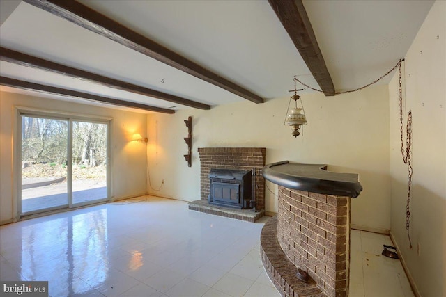 unfurnished living room featuring beamed ceiling, a fireplace, and baseboards