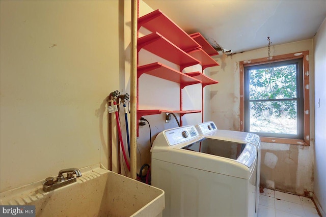 washroom with laundry area, washer and dryer, and a sink