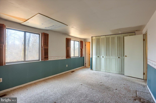 unfurnished bedroom featuring a closet, visible vents, baseboards, and carpet