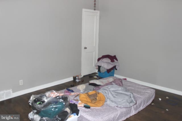 bedroom featuring visible vents, baseboards, and wood finished floors