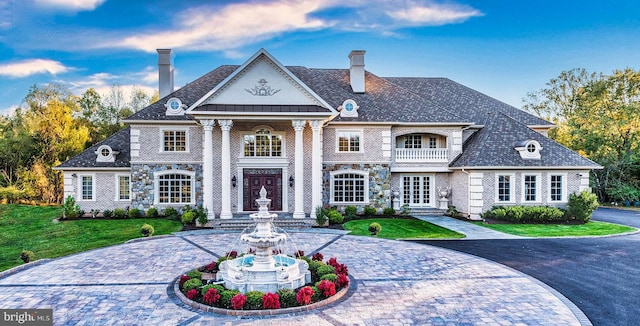 view of front of property featuring french doors, curved driveway, a chimney, and a front yard