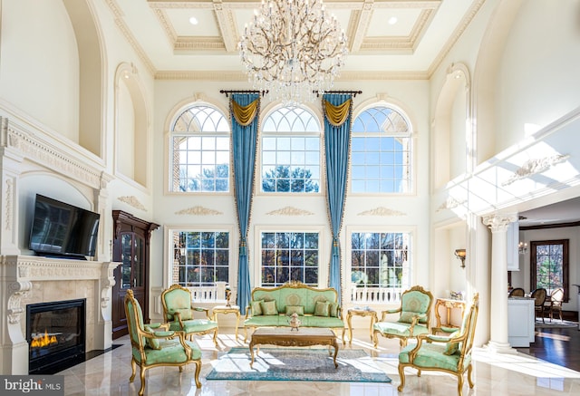 living room featuring a high ceiling, a chandelier, crown molding, and coffered ceiling