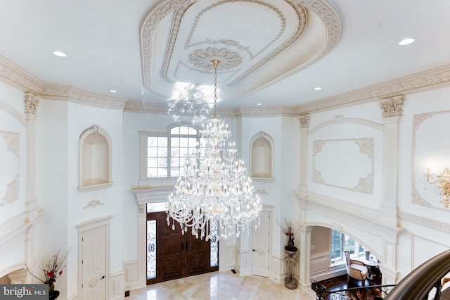 entryway with a tray ceiling, a decorative wall, and a healthy amount of sunlight