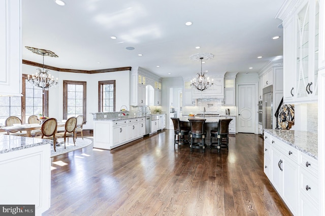 dining area with a chandelier, dark wood-style floors, and ornamental molding