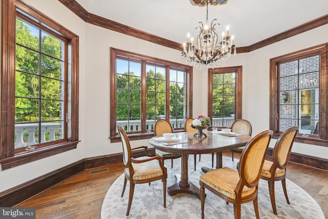 dining area featuring visible vents, crown molding, baseboards, a chandelier, and light wood-type flooring