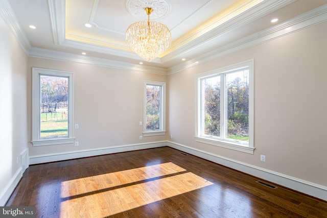 spare room with crown molding, a notable chandelier, dark wood-style floors, and baseboards