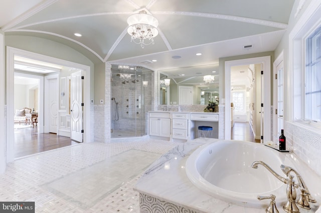 bathroom with visible vents, a shower stall, lofted ceiling, a bath, and vanity