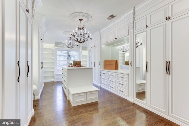 walk in closet featuring dark wood finished floors, visible vents, and a chandelier