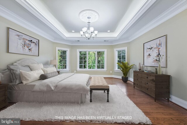 bedroom with a raised ceiling, wood finished floors, crown molding, baseboards, and a chandelier