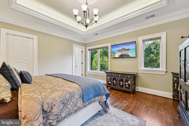 bedroom featuring visible vents, baseboards, a chandelier, ornamental molding, and wood finished floors