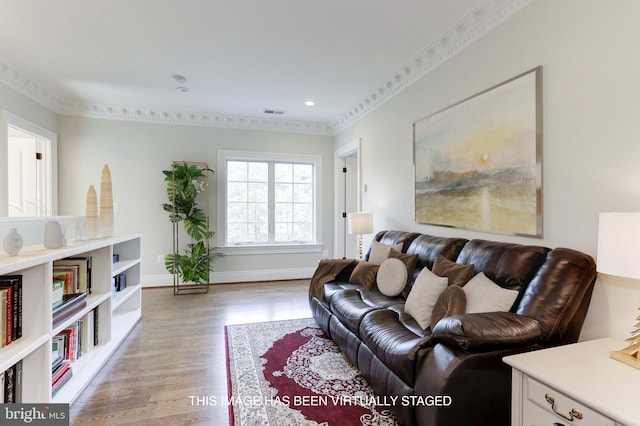 living area featuring visible vents, crown molding, baseboards, recessed lighting, and light wood-style flooring