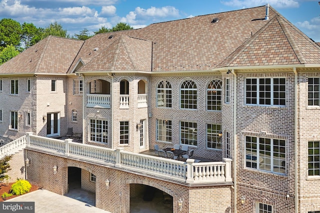 rear view of property with a patio and brick siding