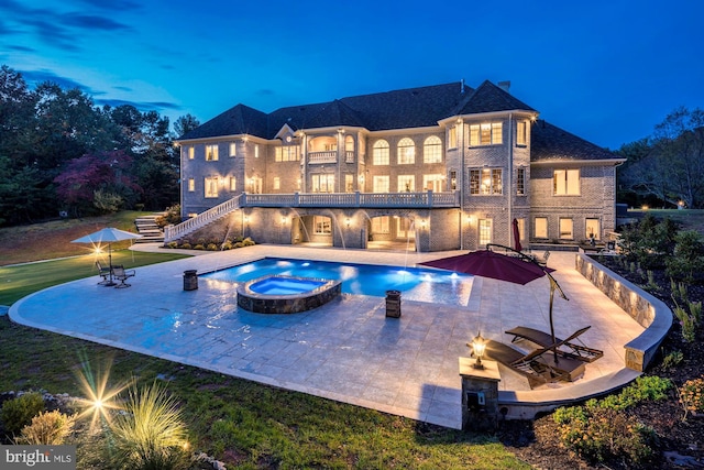 view of pool featuring an outdoor fire pit, a pool with connected hot tub, stairs, and a patio