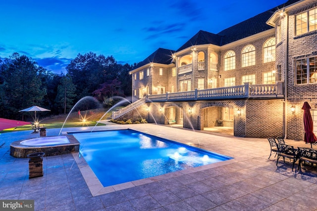 view of swimming pool with a patio area, stairway, and a pool with connected hot tub