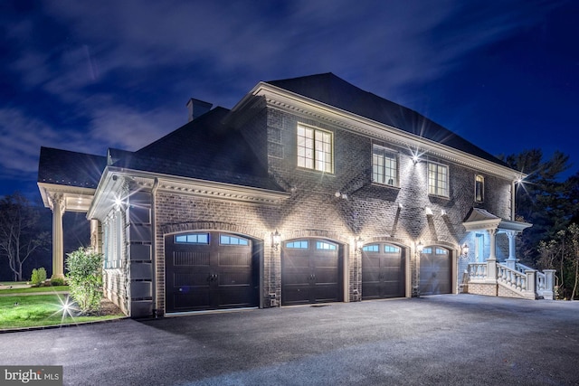 view of front of property with brick siding, driveway, and a garage