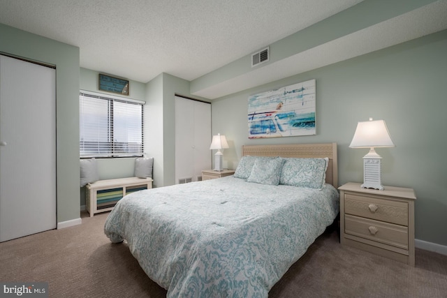 carpeted bedroom with baseboards, visible vents, and a textured ceiling