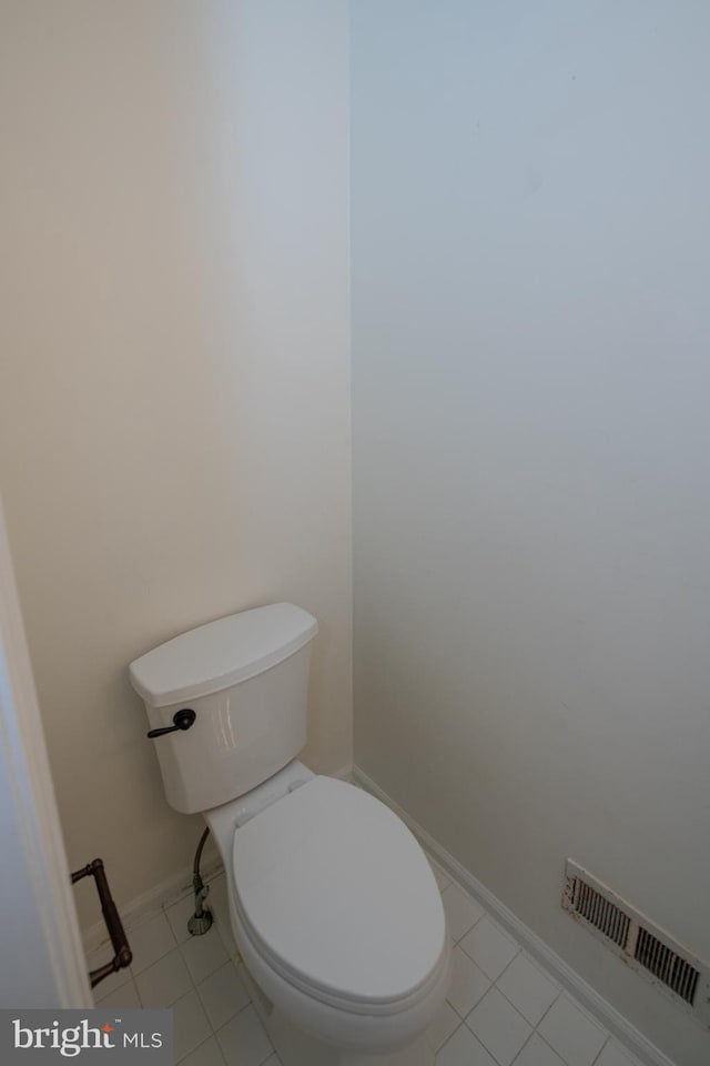 bathroom with tile patterned floors, visible vents, toilet, and baseboards