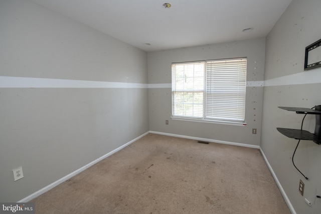 spare room featuring visible vents, baseboards, and carpet