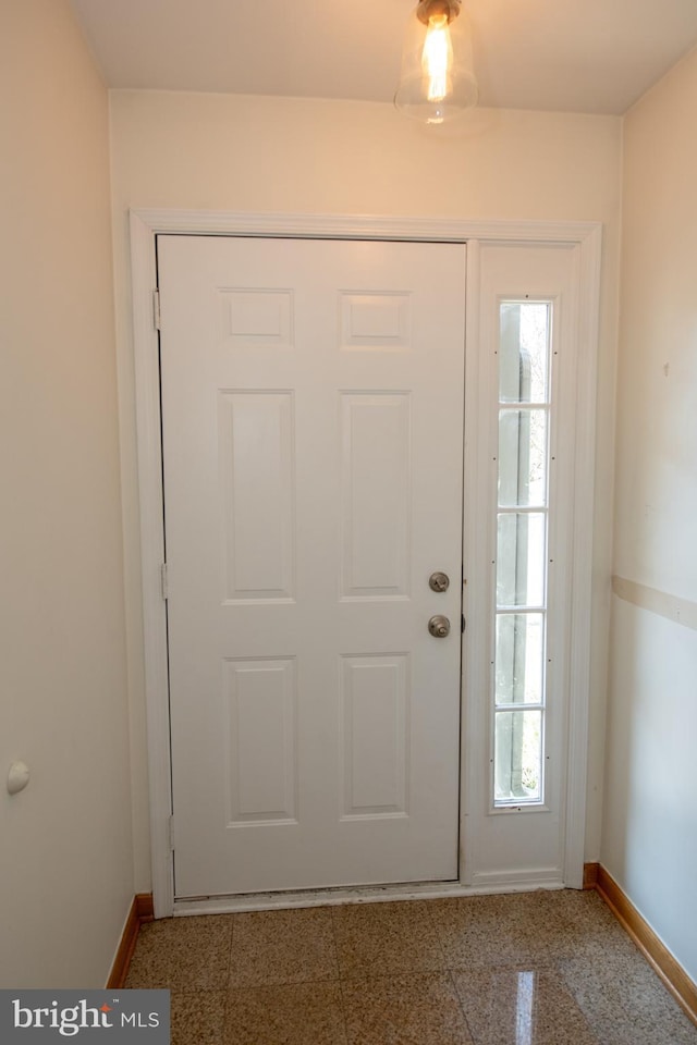 foyer entrance with granite finish floor and baseboards