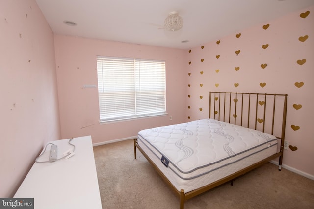 bedroom with light colored carpet and baseboards