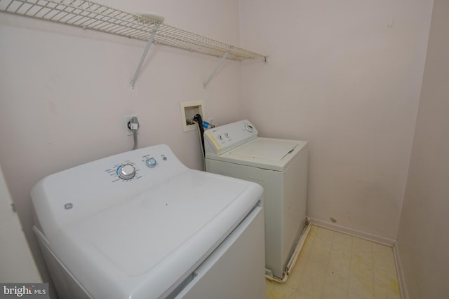 laundry room featuring laundry area, washing machine and dryer, baseboards, and light floors