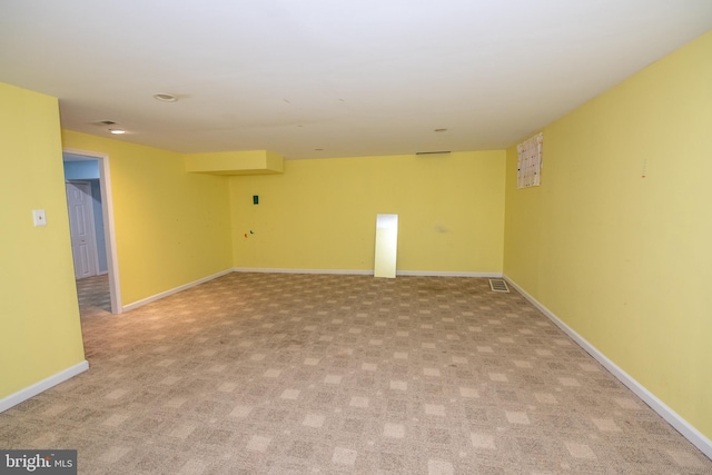 empty room with visible vents, light carpet, and baseboards