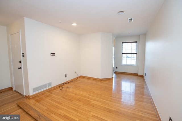 empty room with visible vents, recessed lighting, light wood-type flooring, and baseboards