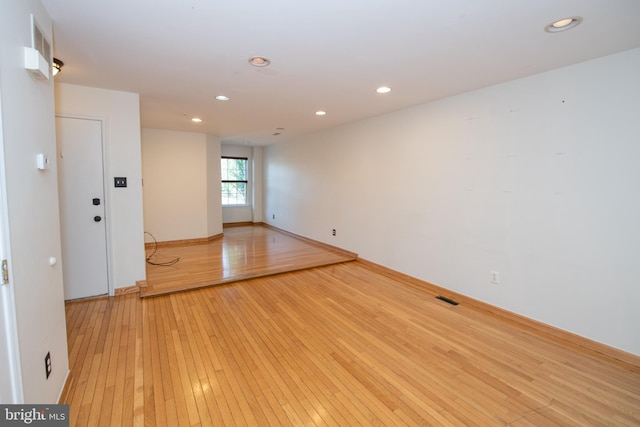 empty room with recessed lighting, visible vents, light wood-style flooring, and baseboards