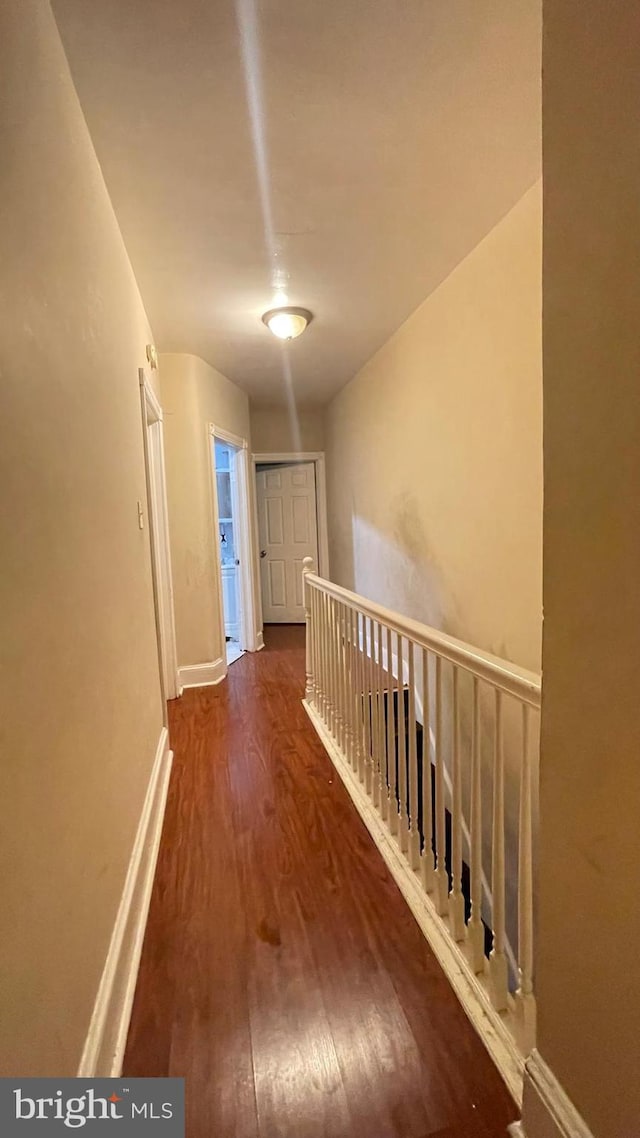 hallway with wood finished floors and baseboards