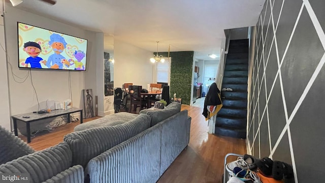 living area featuring a chandelier, stairs, and wood finished floors