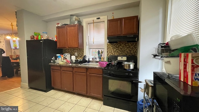 kitchen with black appliances, light tile patterned floors, under cabinet range hood, and a sink