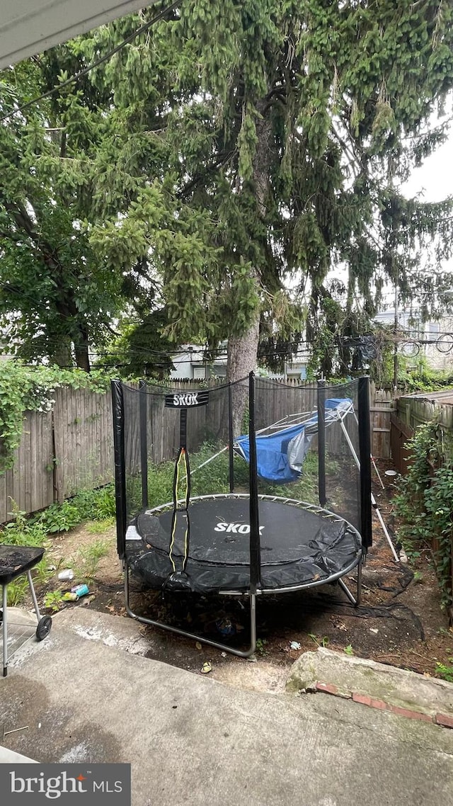 exterior space featuring a trampoline and a fenced backyard