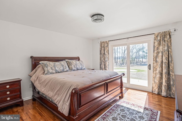 bedroom featuring dark wood finished floors and access to exterior