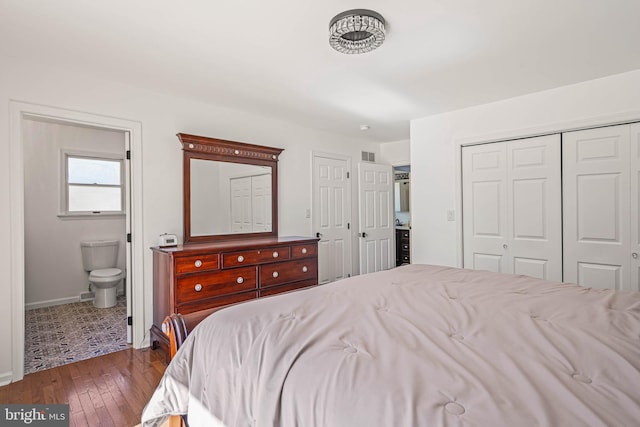 bedroom featuring baseboards, visible vents, dark wood-style flooring, and connected bathroom