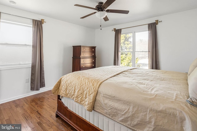 bedroom with wood finished floors, baseboards, and ceiling fan